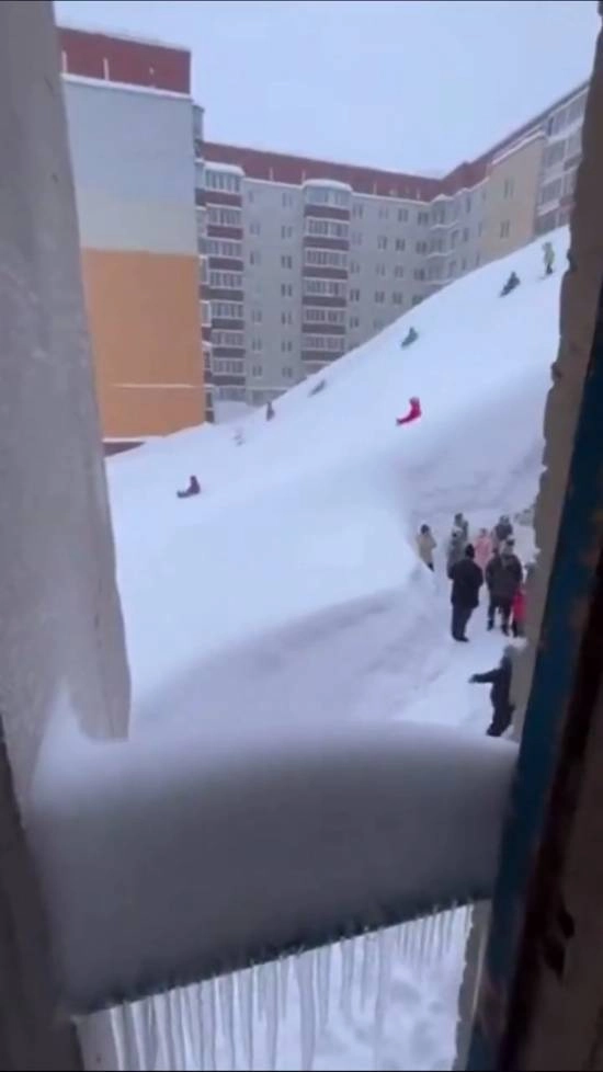俄罗斯某地区暴雪堆积形成公寓楼雪坡此次暴雪强度创近30年降水量纪录